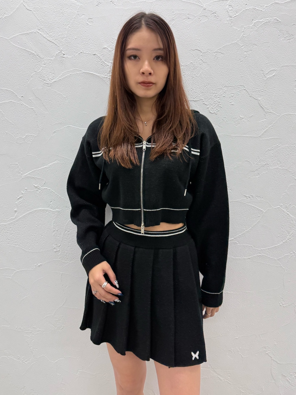 ブラック系のスカート、ホワイト系のブーツ、ブラック系のニット/セーターを着用したレディースの冬コーディネートの4枚目の写真