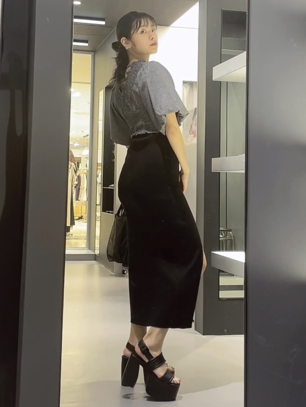 ブラック系のワンピース、ブラック系のTシャツ/カットソー、ブラック系のサンダルを着用したレディースの夏コーディネートの2枚目の写真