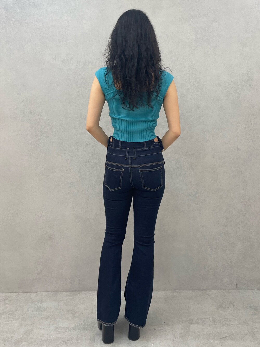 ブルー系のデニムパンツ、ブラック系のブーツ、シルバー系のネックレスを着用したレディースの夏コーディネートの3枚目の写真