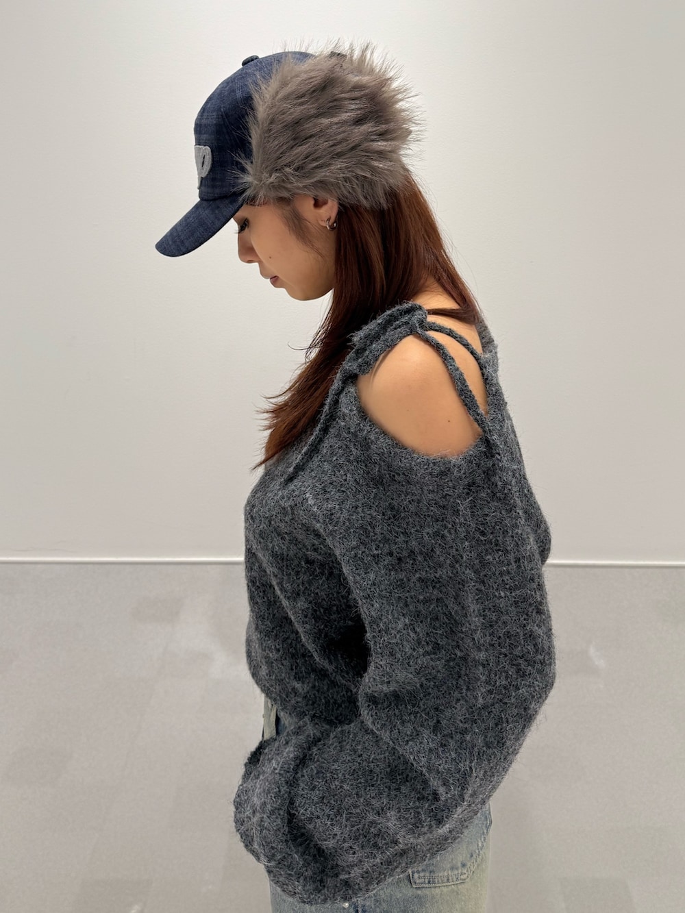 グレー系のニット/セーター、ブラック系のブーツ、ブルー系のデニムパンツを着用したレディースの冬コーディネートの5枚目の写真