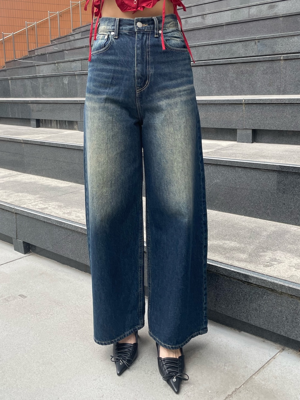 レッド系のTシャツ/カットソー、ブルー系のデニムパンツ、ブラック系のハンドバッグを着用したレディースの春コーディネートの7枚目の写真