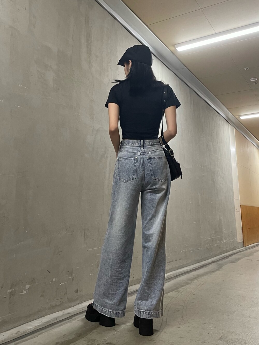 ブラック系のTシャツ/カットソー、ブラック系のショルダーバッグ、ブルー系のデニムパンツを着用したレディースの夏コーディネートの9枚目の写真