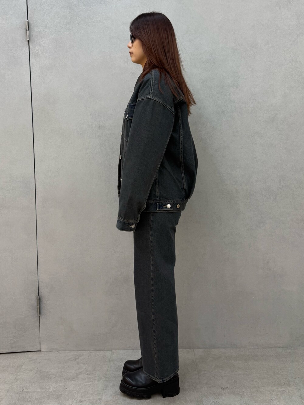 ブラック系のニット/セーター、ブルー系のブルゾン、ブルー系のデニムパンツを着用したレディースの冬コーディネートの2枚目の写真