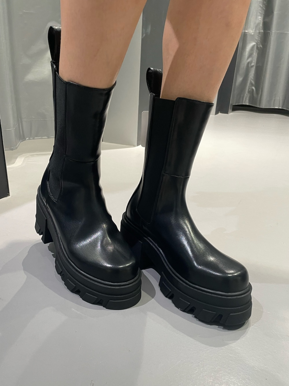 ブラック系のニット/セーター、ブルー系のデニムパンツ、ブラック系のブーツを着用したレディースの冬コーディネートの9枚目の写真