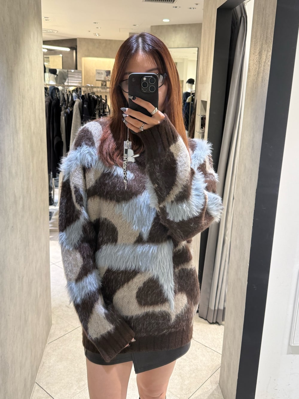 ブラウン系のニット/セーター、ブラック系のスカート、ブラック系のブーツを着用したレディースの秋コーディネートの4枚目の写真