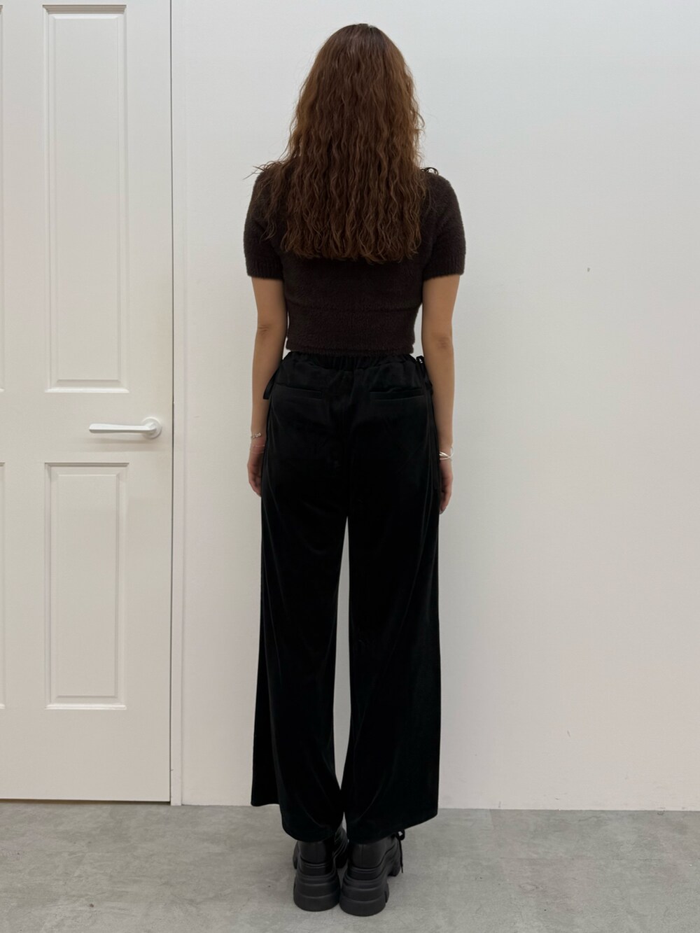 ブラウン系のニット/セーター、ブラック系のその他パンツ、ブラック系のローファーを着用したレディースの夏コーディネートの3枚目の写真