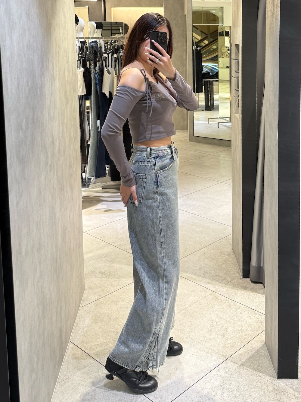 グレー系のTシャツ/カットソー、ブルー系のデニムパンツ、ブラック系のスニーカーを着用したレディースの春コーディネートの2枚目の写真