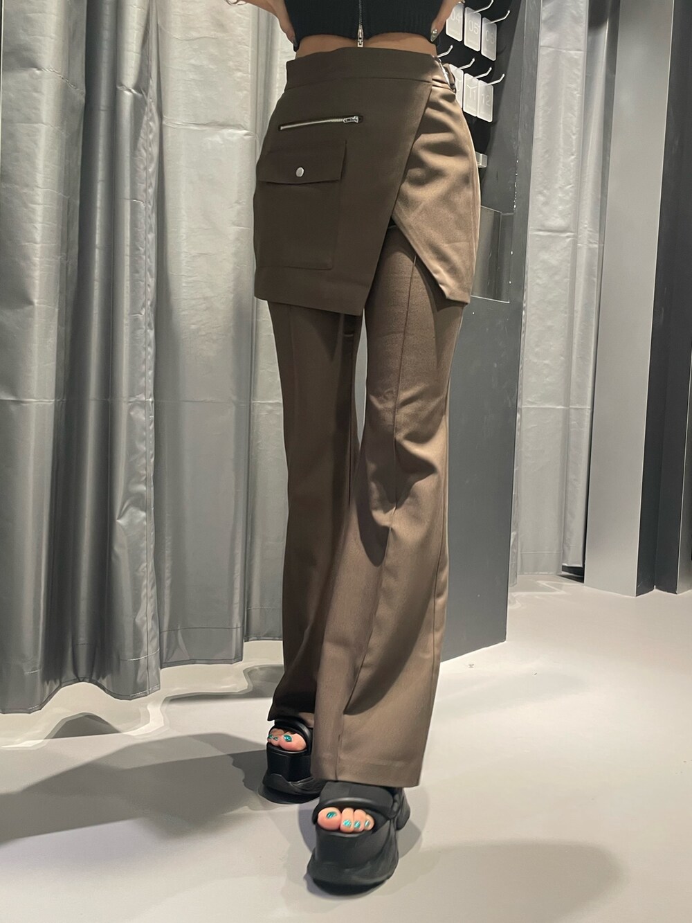 ブラック系のニット/セーター、ブラウン系のその他パンツ、ブラック系のサンダルを着用したレディースの夏コーディネートの6枚目の写真