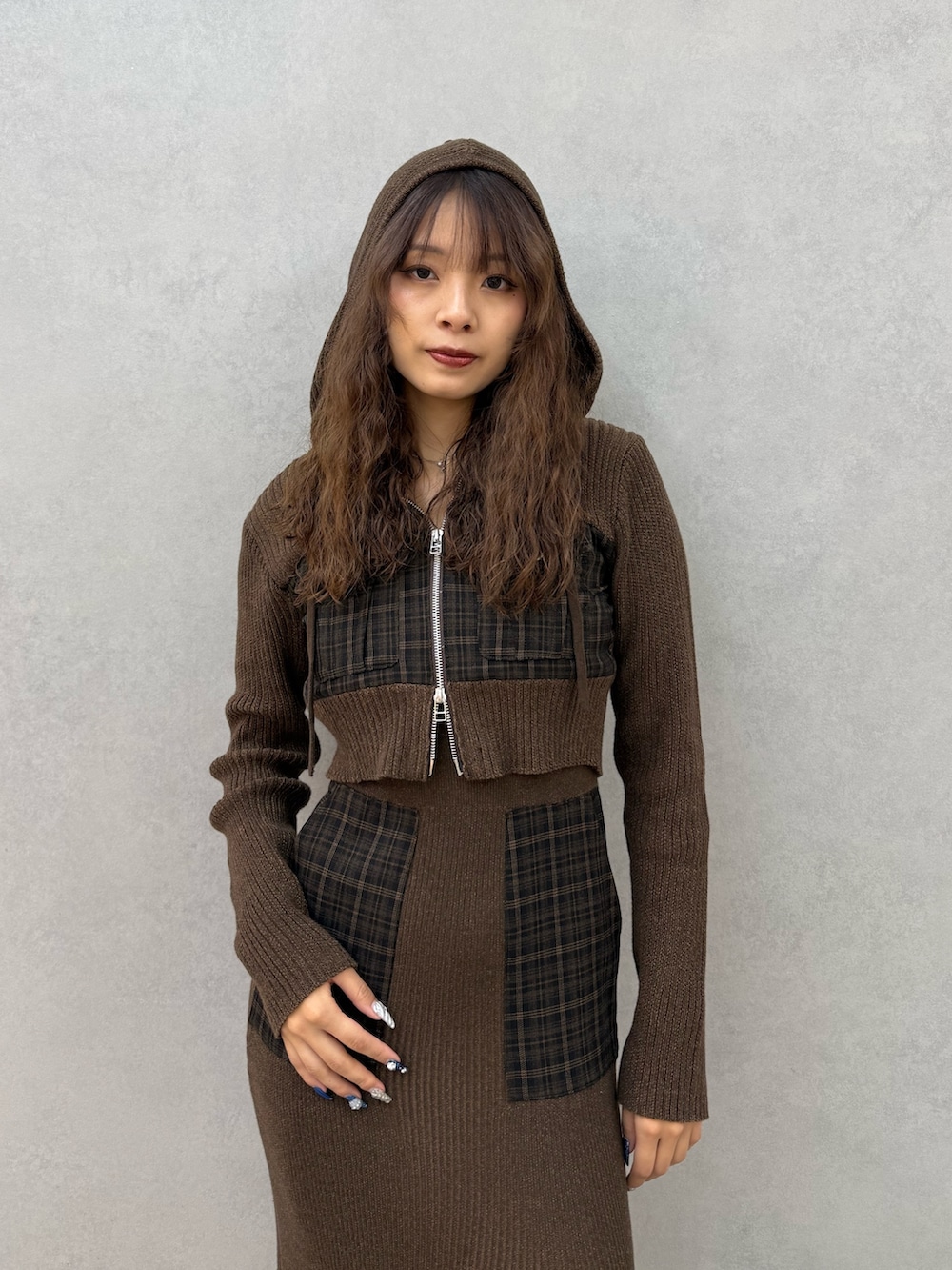 グリーン系のニット/セーター、グリーン系のワンピース、ブラック系のブーツを着用したレディースの秋コーディネートの4枚目の写真