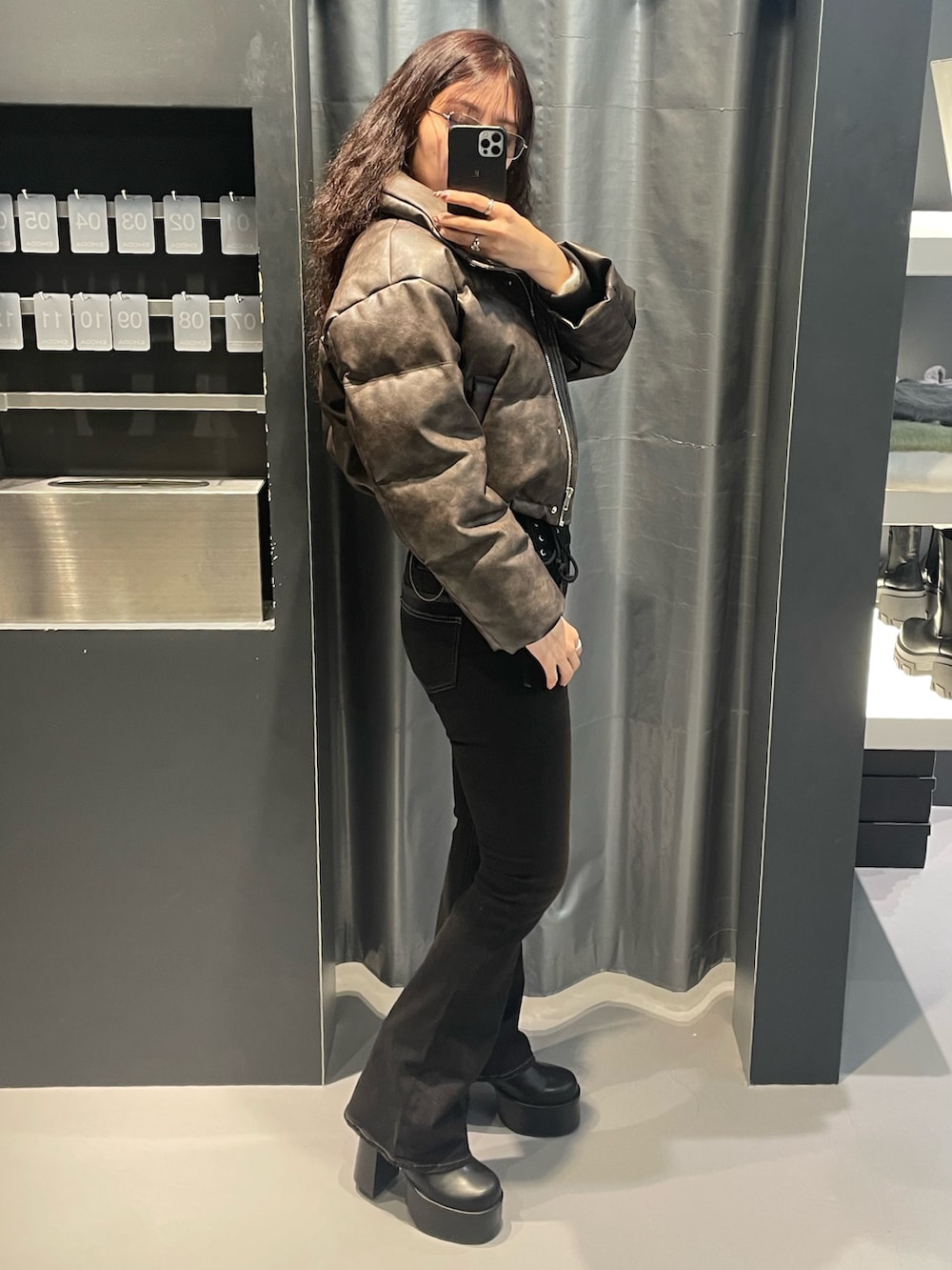 ホワイト系のニット/セーター、ブラウン系のダウンジャケット/コート、ブラック系のデニムパンツを着用したレディースの冬コーディネートの2枚目の写真