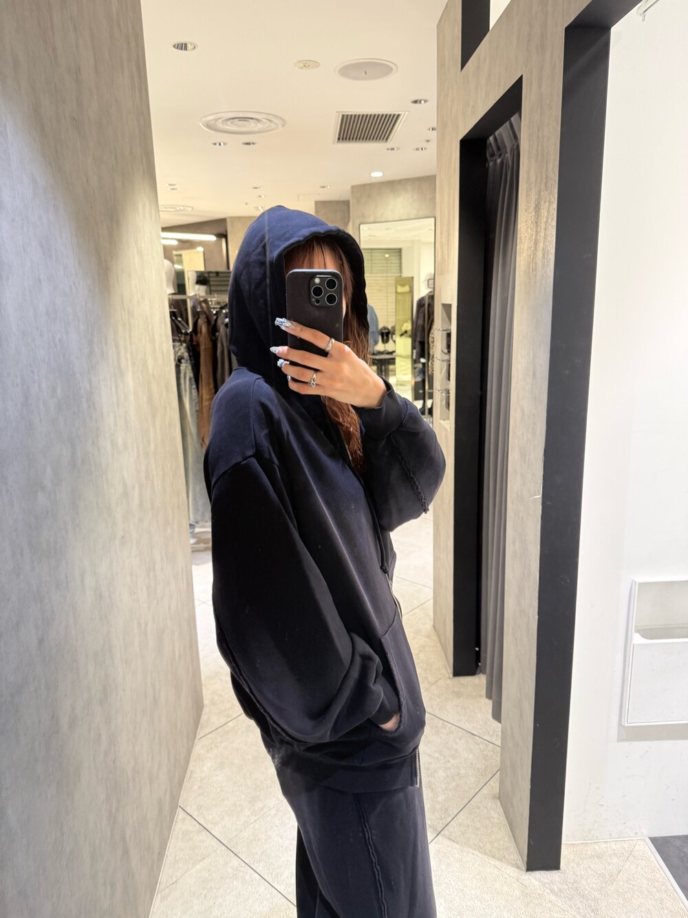 ブラック系のパーカー、ブラック系のスウェットパンツ、ブラック系のブーツを着用したレディースの秋コーディネートの5枚目の写真