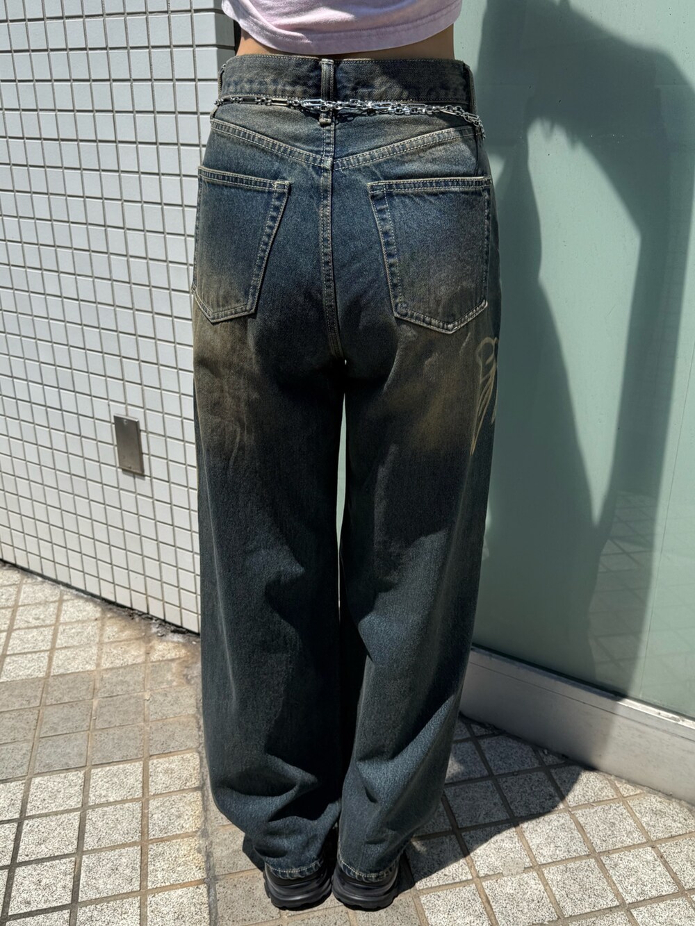 ホワイト系のTシャツ/カットソー、ブルー系のデニムパンツ、ブラック系のブーツを着用したレディースの夏コーディネートの7枚目の写真