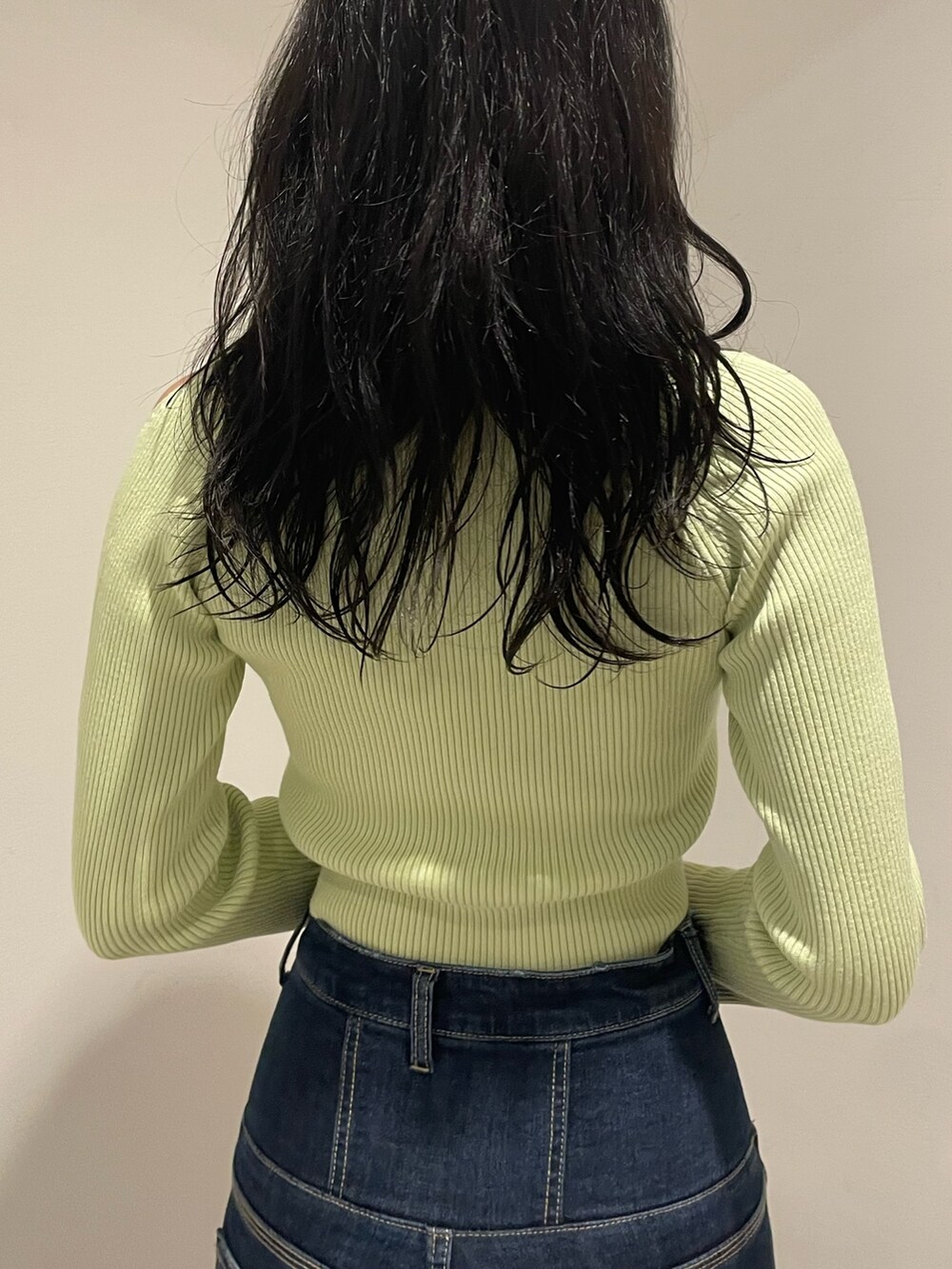 グリーン系のニット/セーター、ブルー系のデニムパンツ、ブラック系のブーツを着用したレディースの冬コーディネートの6枚目の写真