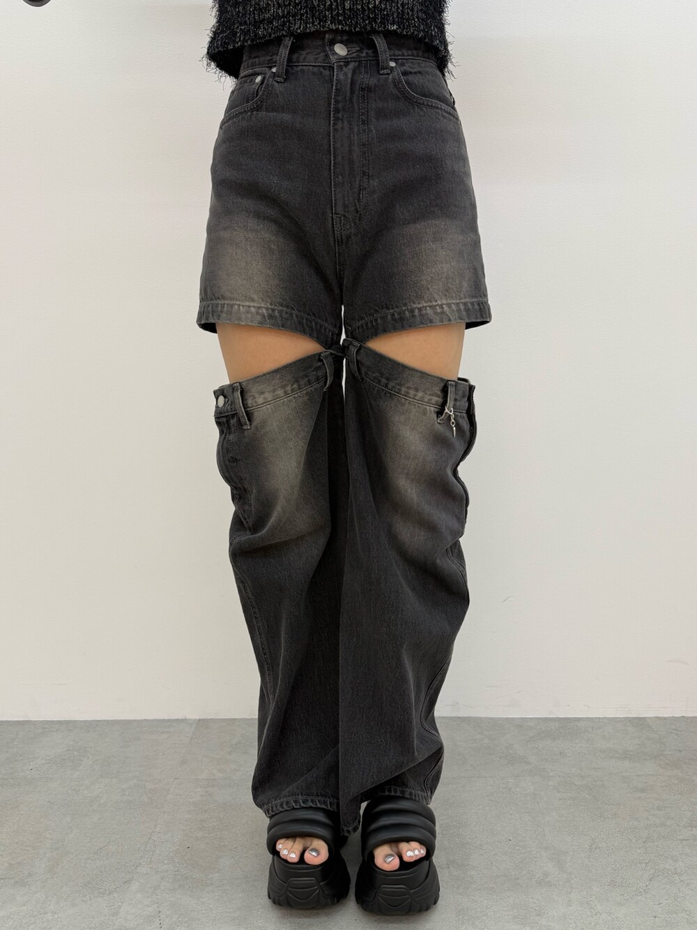 ブラック系のニット/セーター、ブラック系のデニムパンツ、ブラック系のハンドバッグを着用したレディースの夏コーディネートの7枚目の写真