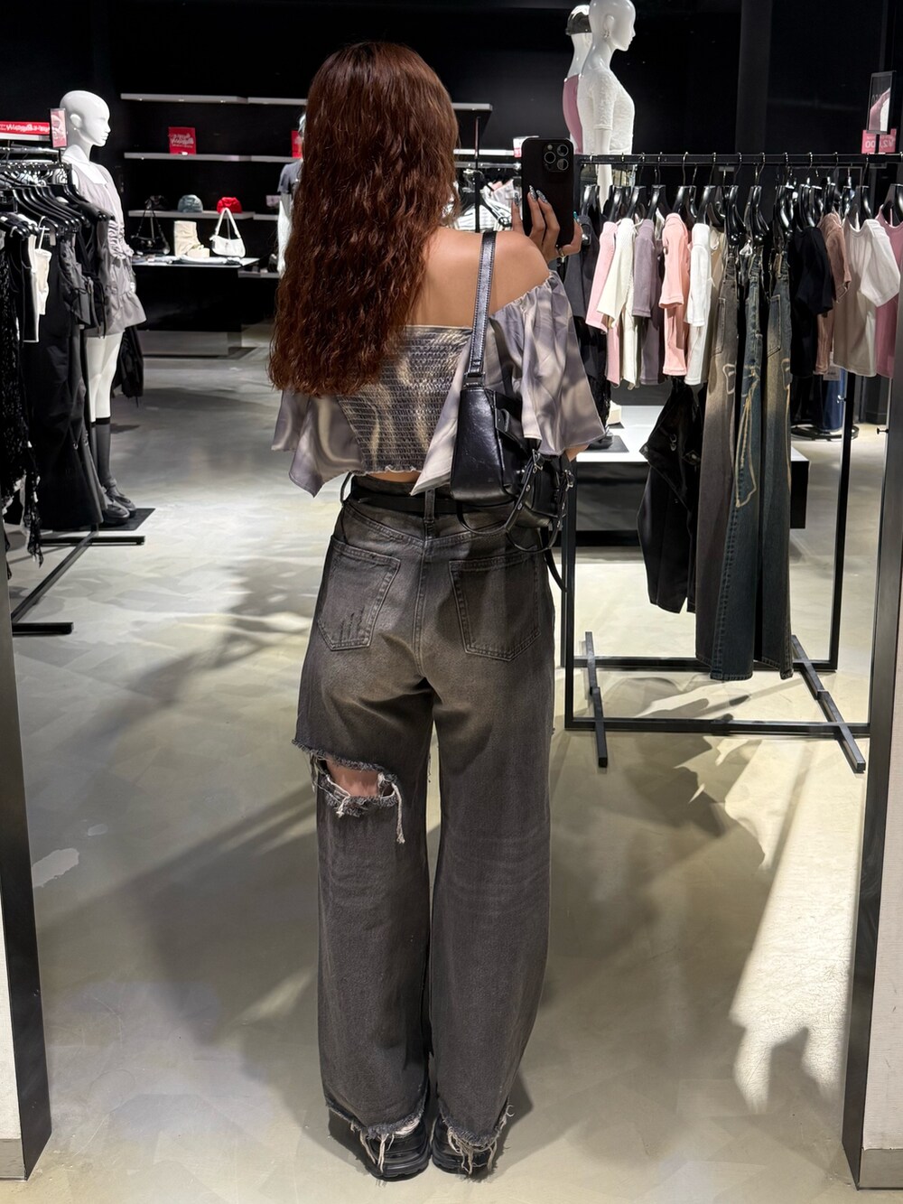 ベージュ系のTシャツ/カットソー、ブラック系のハンドバッグ、ブラック系のデニムパンツを着用したレディースの夏コーディネートの3枚目の写真