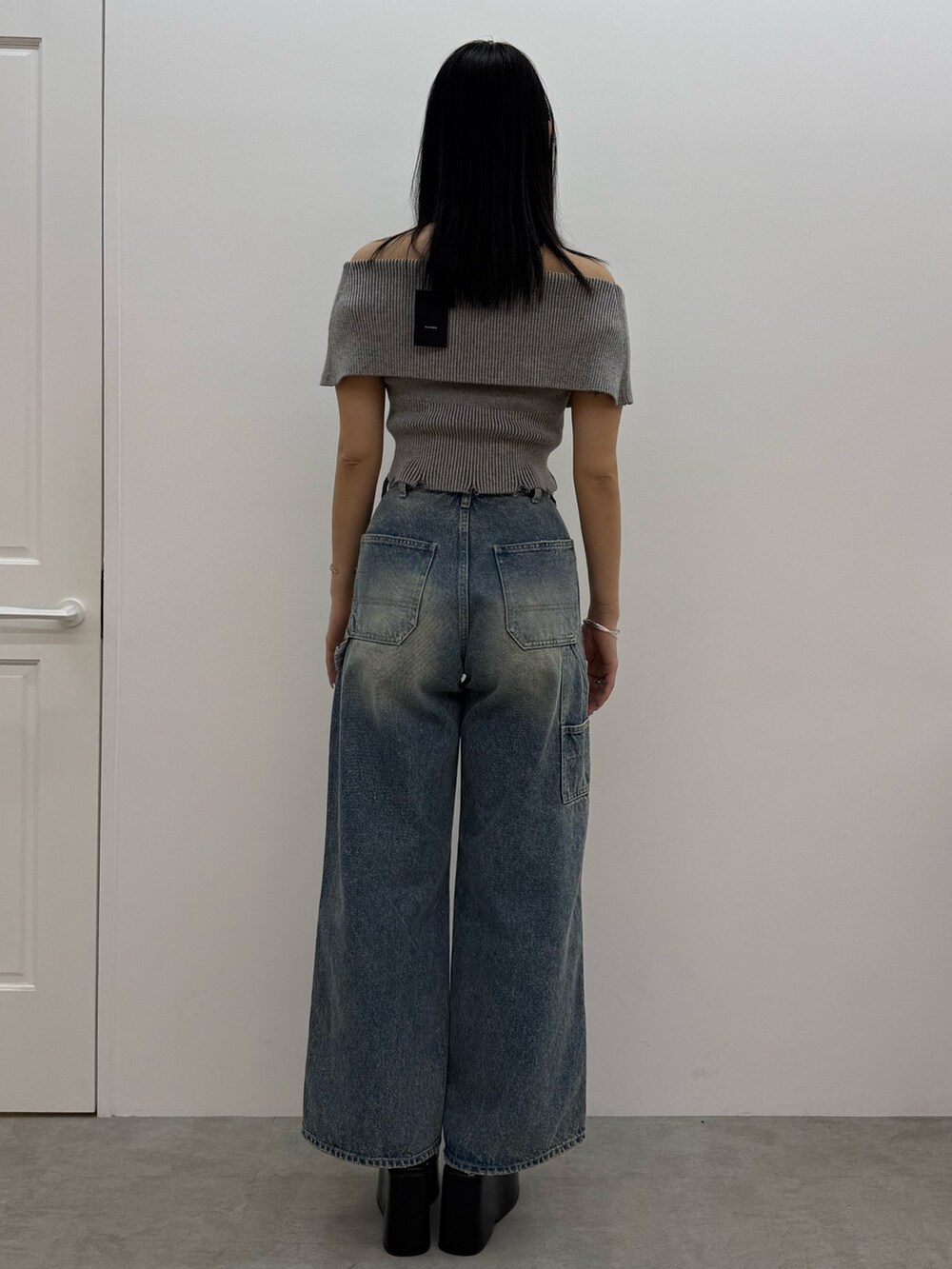 グレー系のニット/セーター、ブルー系のデニムパンツ、ブラック系のサンダルを着用したレディースの春コーディネートの3枚目の写真