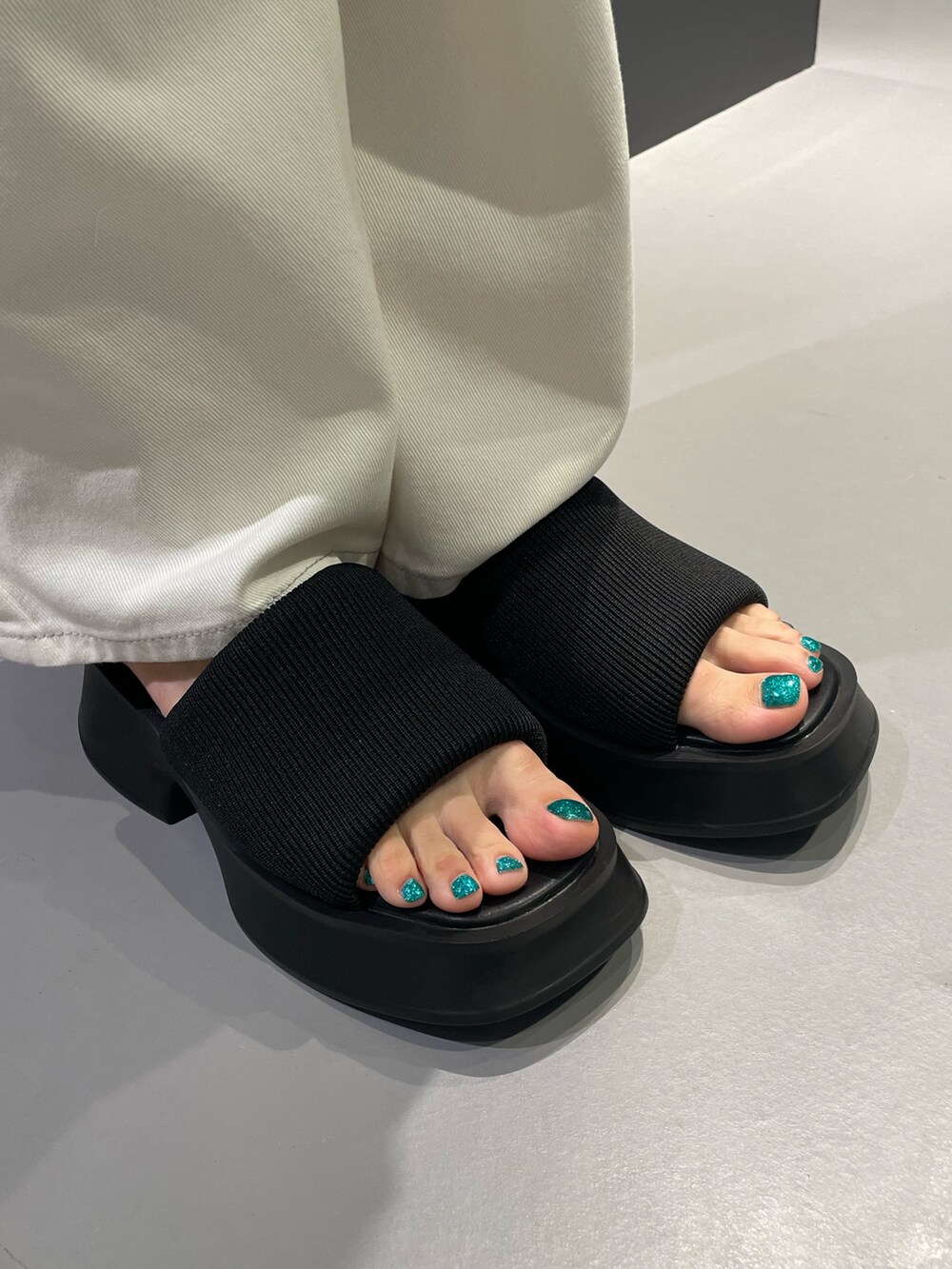 ブラック系のTシャツ/カットソー、ホワイト系のカーゴパンツ、ブラック系のサンダルを着用したレディースの夏コーディネートの8枚目の写真