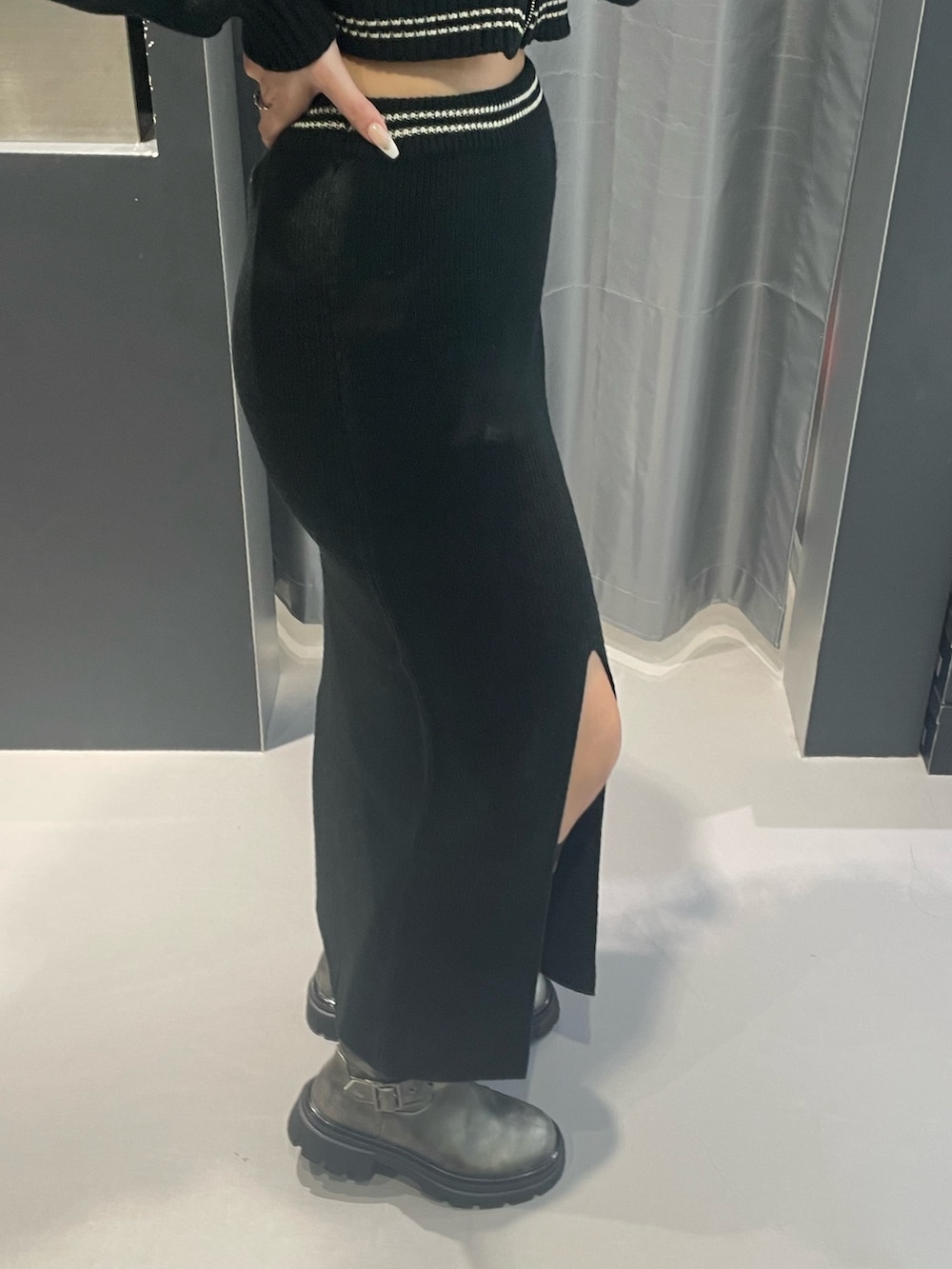 ブラック系のニット/セーター、ブラック系のスカート、シルバー系のブーツを着用したレディースの冬コーディネートの8枚目の写真