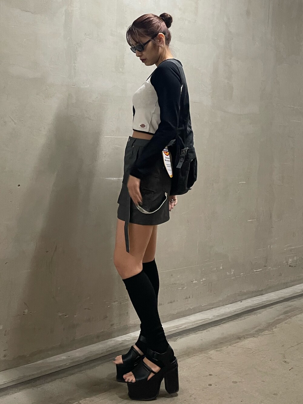 ブラック系のハンドバッグ、ホワイト系のTシャツ/カットソー、グレー系のスカートを着用したレディースの春コーディネートの2枚目の写真