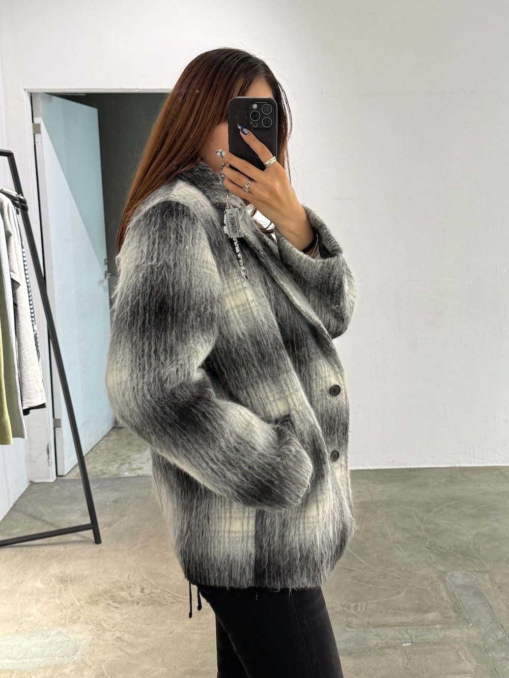 ホワイト系のニット/セーター、ブラック系のその他アウター、ブラック系のデニムパンツを着用したレディースの冬コーディネートの5枚目の写真