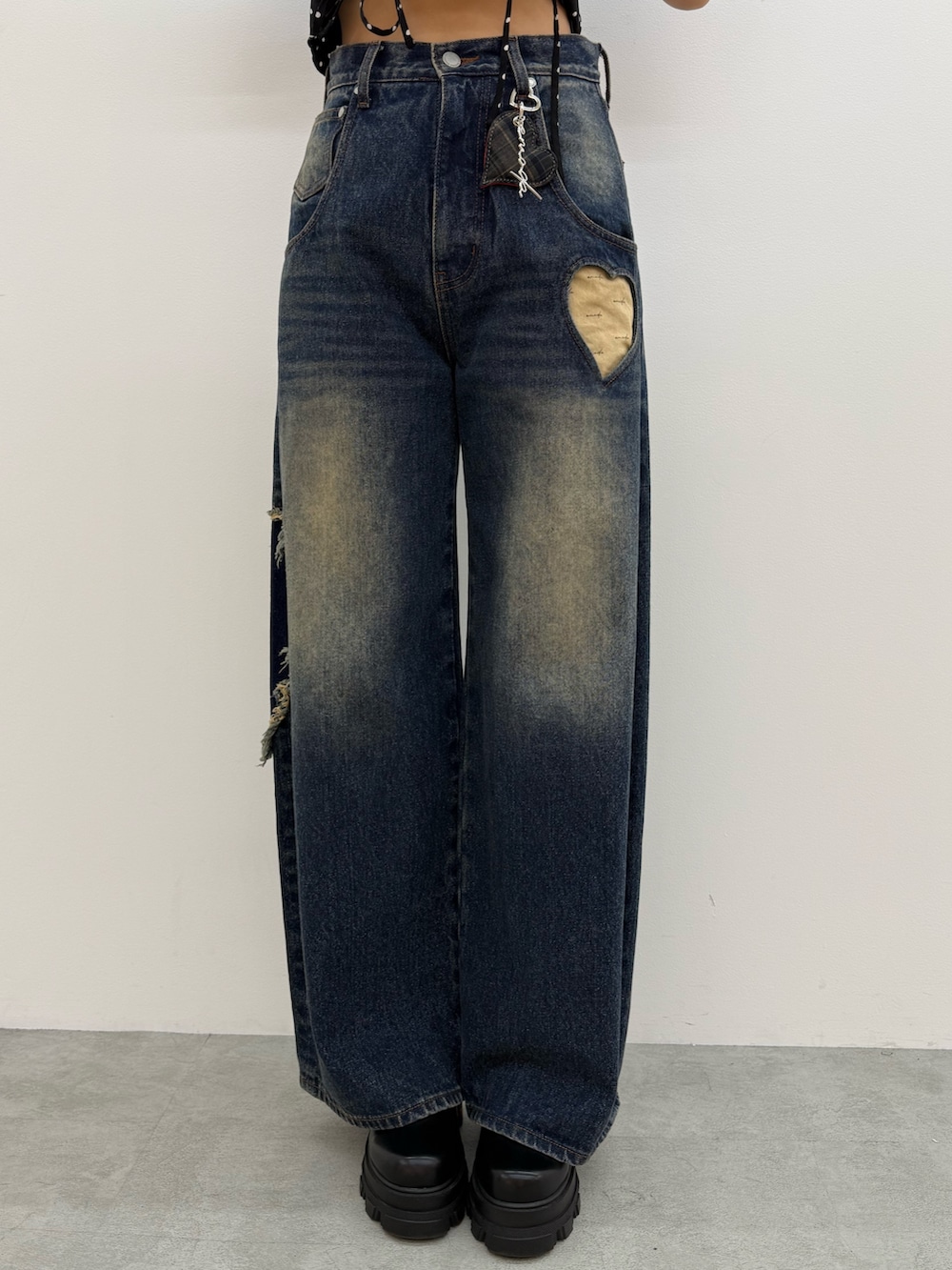 レッド系のニット/セーター、ブルー系のデニムパンツ、ブラック系のブーツを着用したレディースの夏コーディネートの5枚目の写真