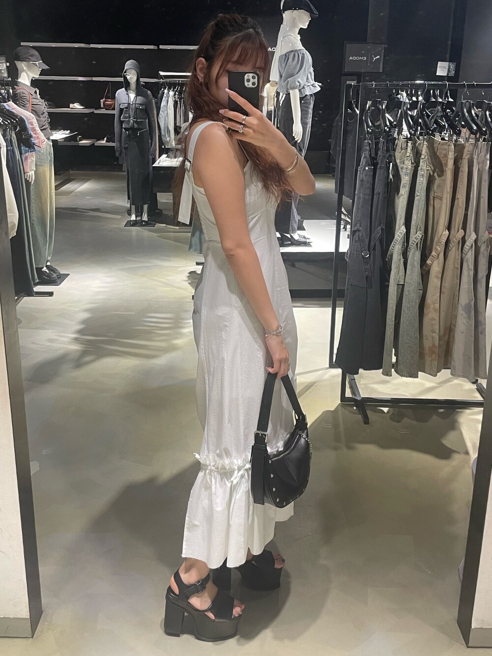 ブラック系のTシャツ/カットソー、ホワイト系のワンピース、ブラック系のハンドバッグを着用したレディースの春コーディネートの2枚目の写真