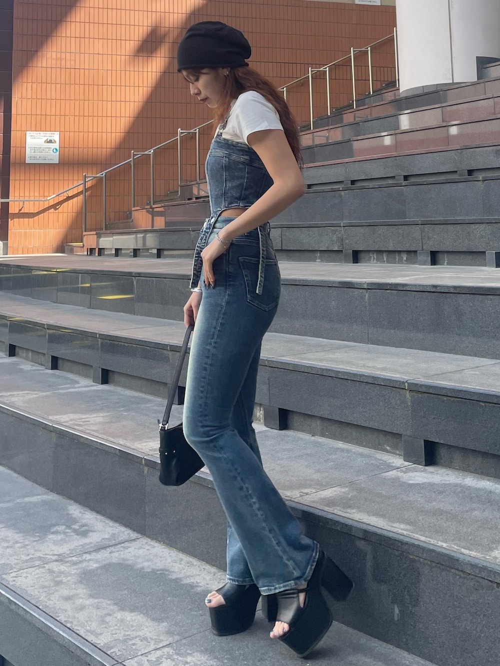 ホワイト系のTシャツ/カットソー、ブルー系のサロペット/オーバーオール、ブラック系のハンドバッグを着用したレディースの春コーディネートの2枚目の写真