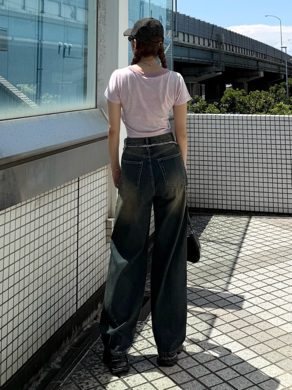 ピンク系のTシャツ/カットソー、ブルー系のデニムパンツ、ブラック系のショルダーバッグを着用したレディースの夏コーディネートの3枚目の写真