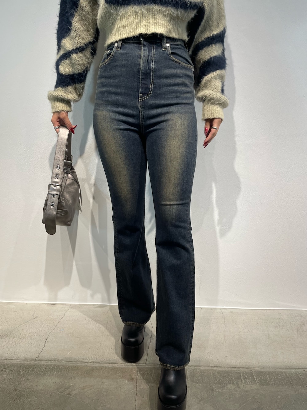 ホワイト系のニット/セーター、ブルー系のデニムパンツ、ブラウン系のショルダーバッグを着用したレディースの秋コーディネートの7枚目の写真