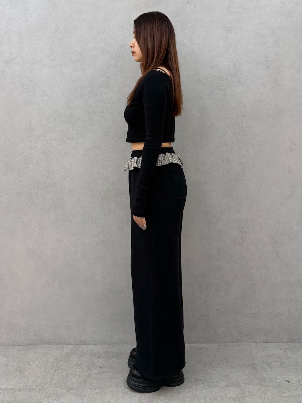 ブラック系のTシャツ/カットソー、ブラック系のスウェットパンツ、ブラック系のローファーを着用したレディースの冬コーディネートの2枚目の写真