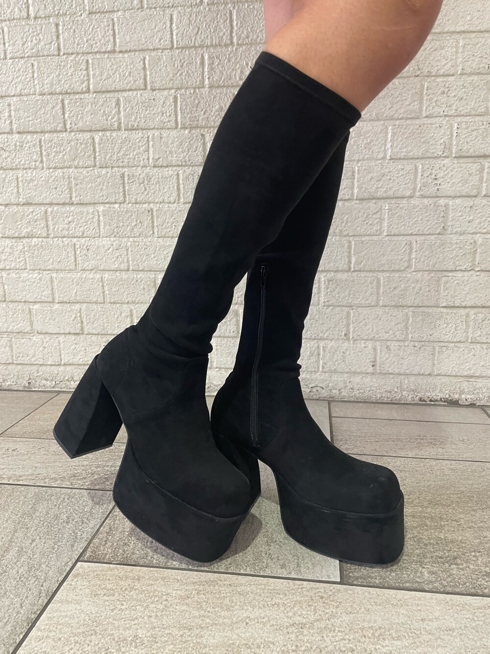 ホワイト系のTシャツ/カットソー、ホワイト系のダウンベスト、ブラック系のスカートを着用したレディースの秋コーディネートの9枚目の写真