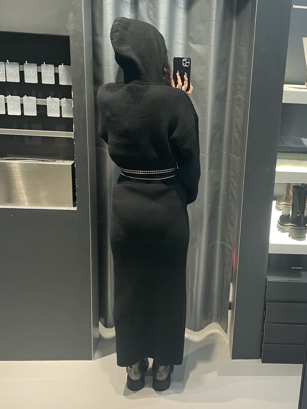 ブラック系のニット/セーター、ブラック系のスカート、シルバー系のブーツを着用したレディースの冬コーディネートの3枚目の写真