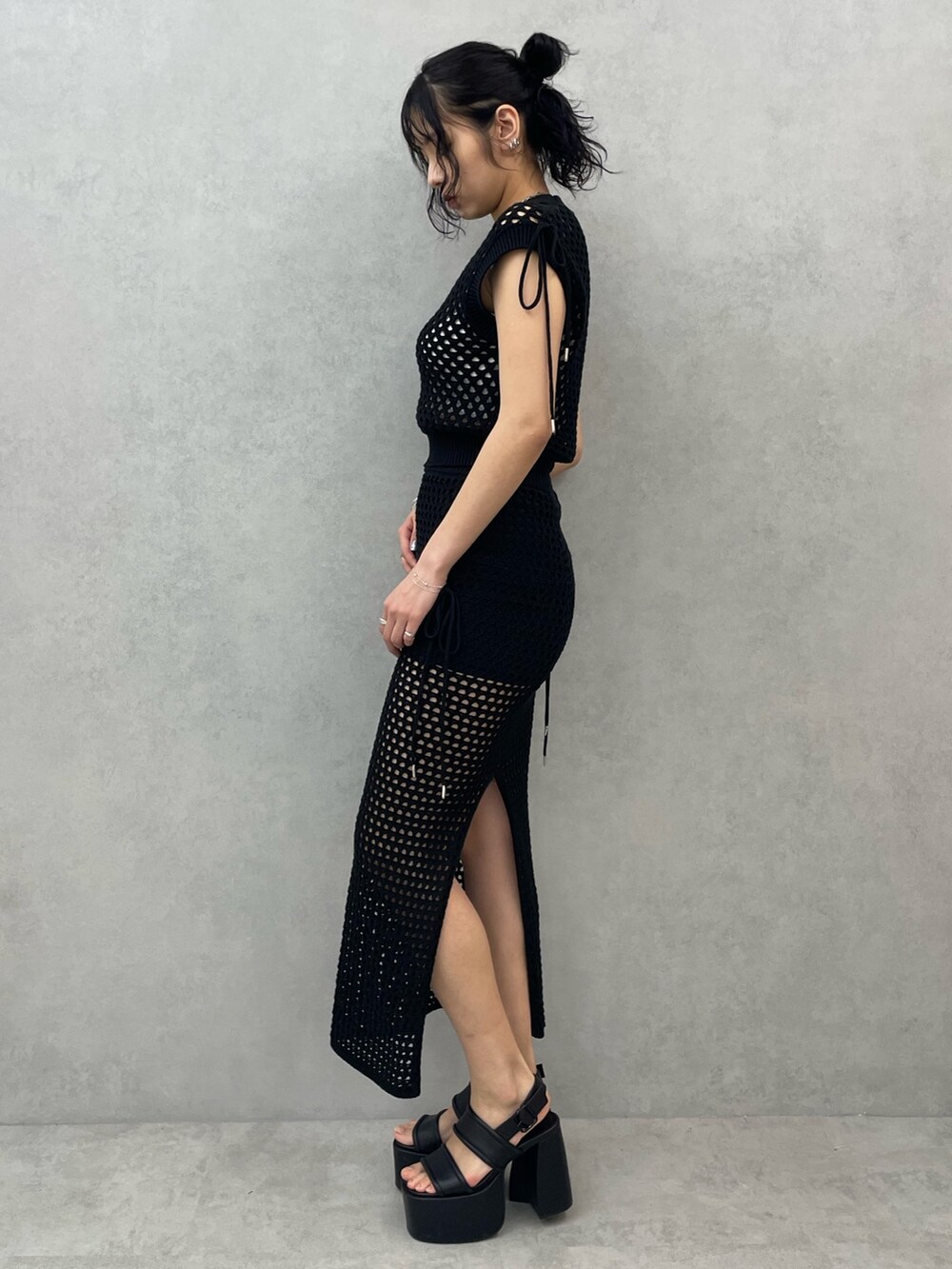 ホワイト系のキャミソール、ブラック系のタンクトップ、ブラック系のスカートを着用したレディースの春コーディネートの2枚目の写真