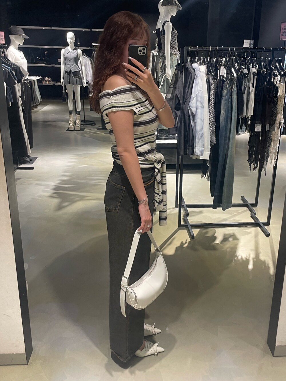 その他のニット/セーター、ブルー系のデニムパンツ、ホワイト系のハンドバッグを着用したレディースの春コーディネートの2枚目の写真