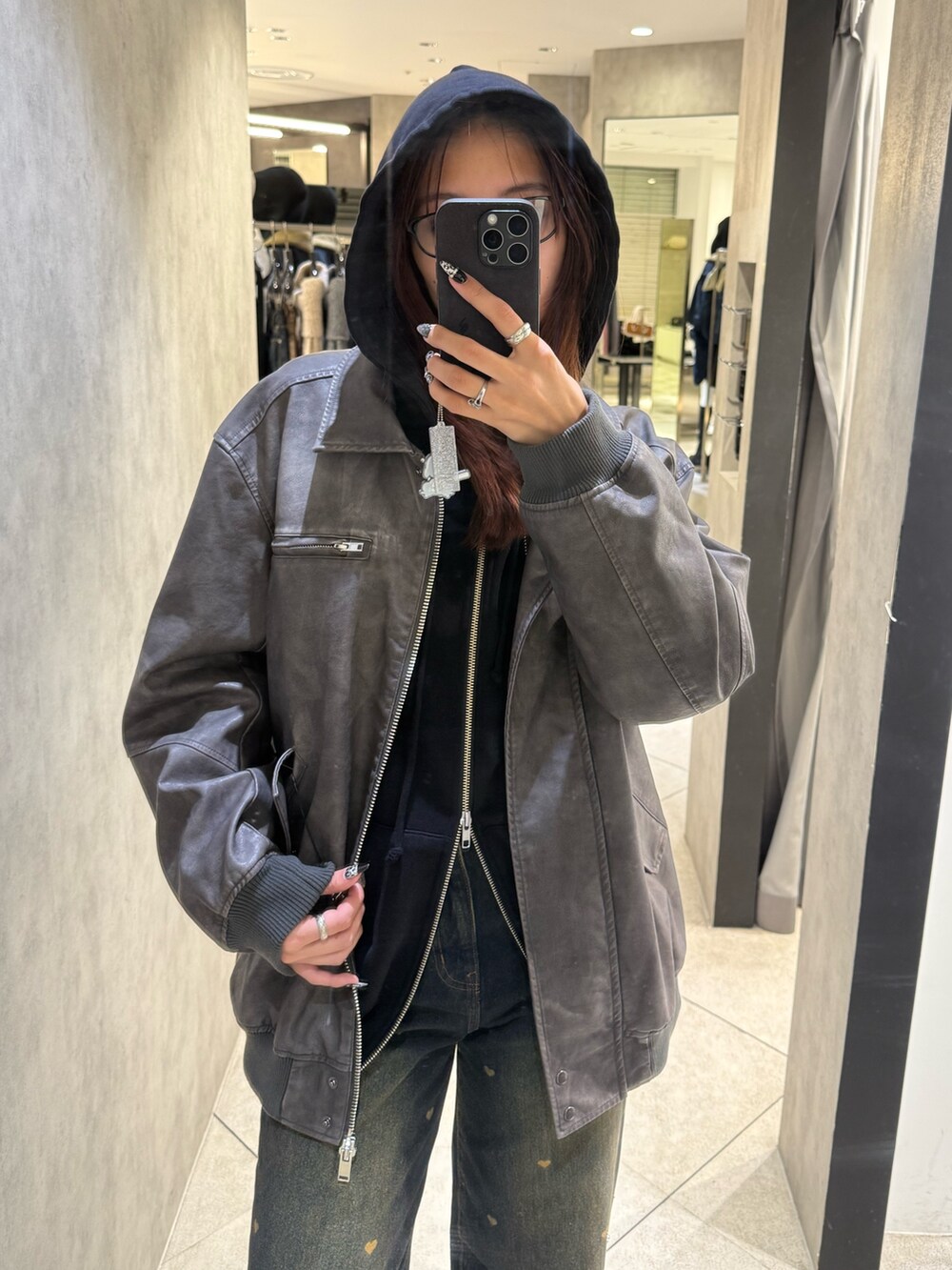 ブラック系のパーカー、グレー系のブルゾン、ブルー系のデニムパンツを着用したレディースの秋コーディネートの4枚目の写真