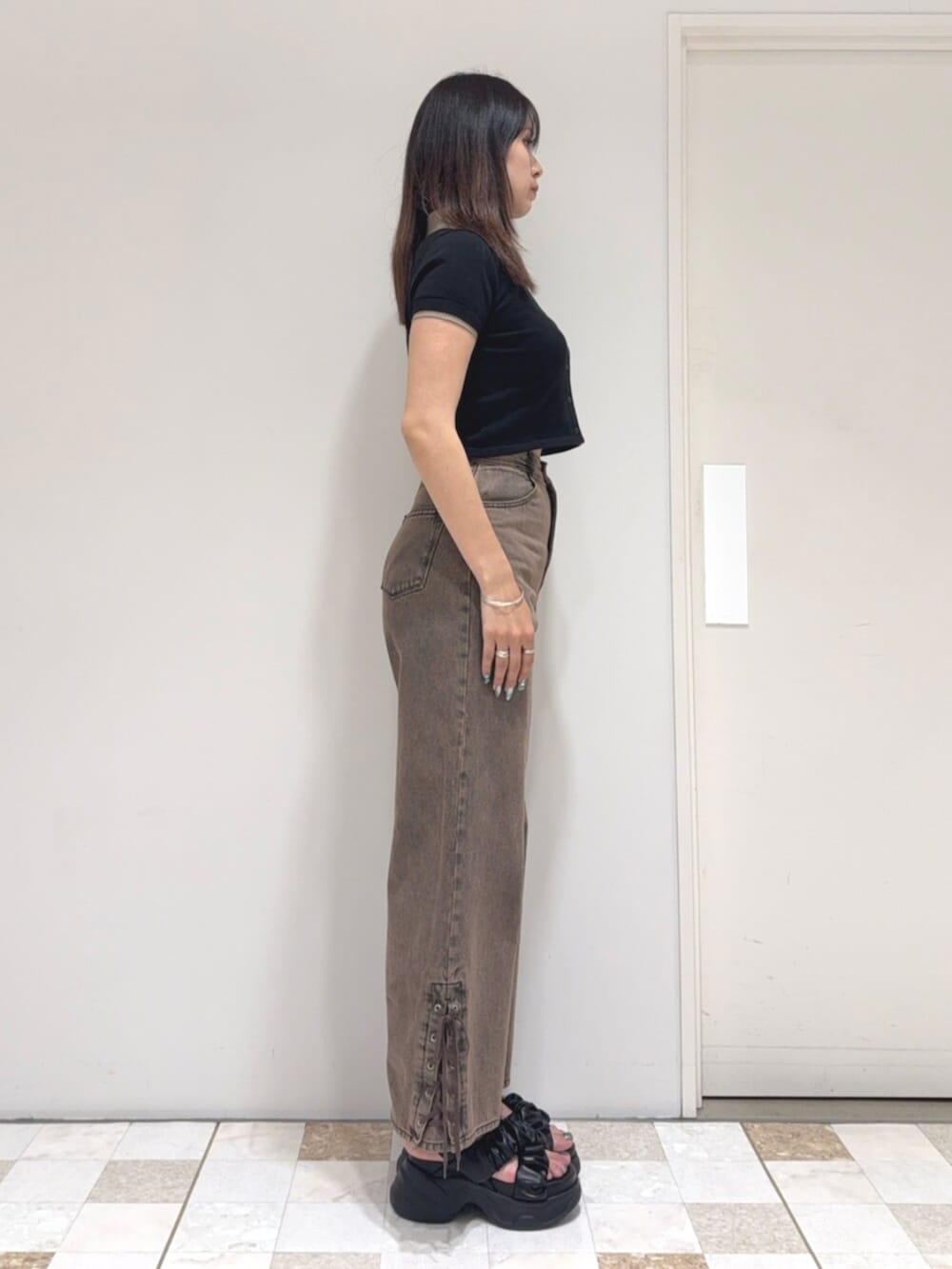 ブラック系のカーディガン/ボレロ、ブラウン系のデニムパンツ、ブラック系のサンダルを着用したレディースの夏コーディネートの2枚目の写真