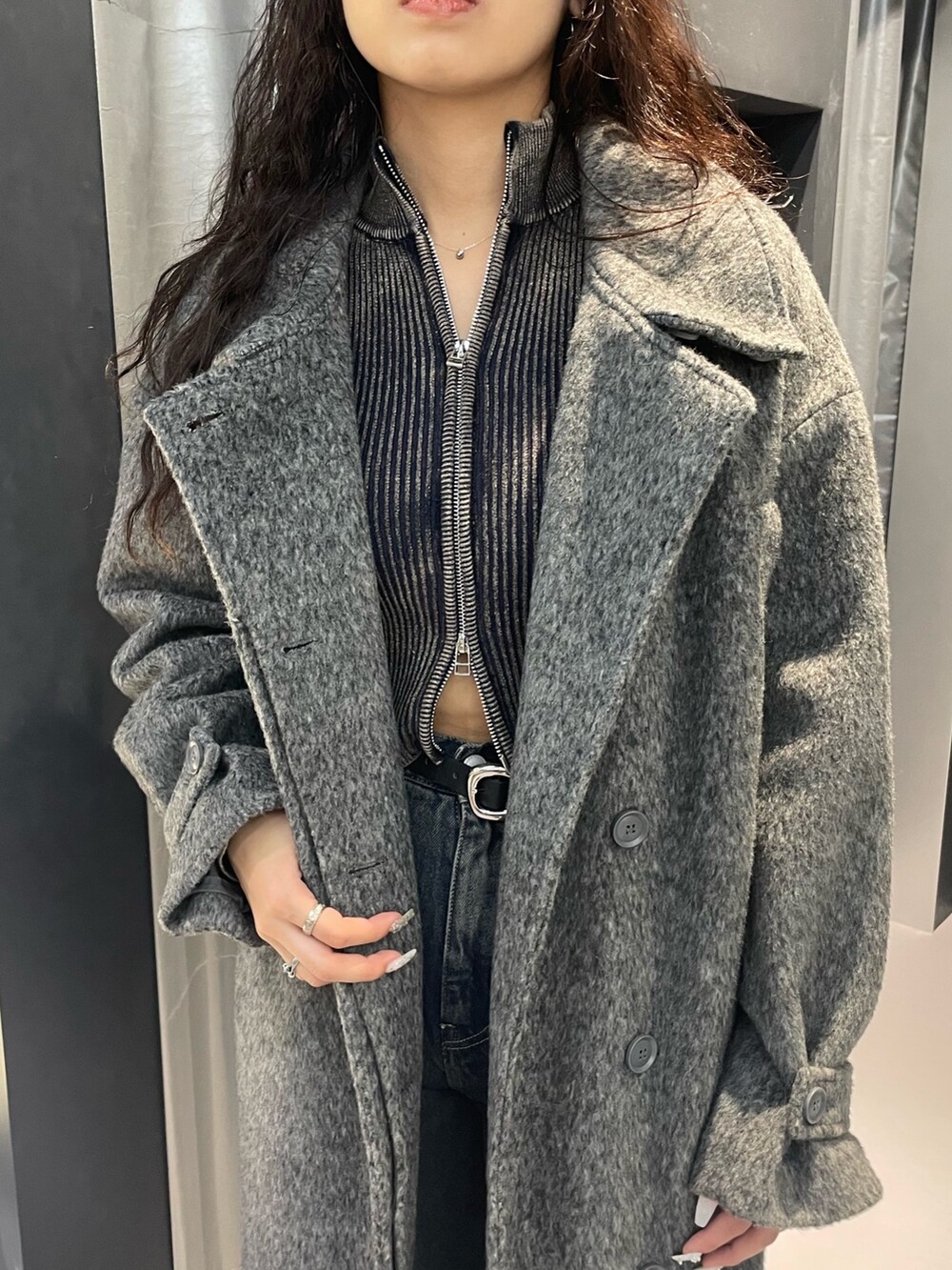 ブラック系のニット/セーター、グレー系のその他アウター、ブルー系のデニムパンツを着用したレディースの冬コーディネートの4枚目の写真