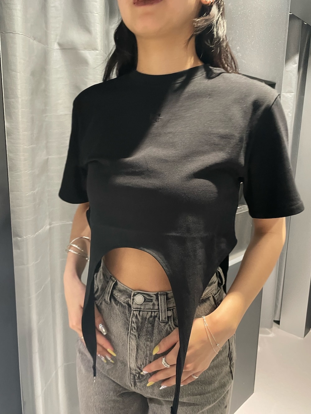 ブラック系のサンダル、ブラック系のTシャツ/カットソー、グレー系のデニムパンツを着用したレディースの春コーディネートの4枚目の写真