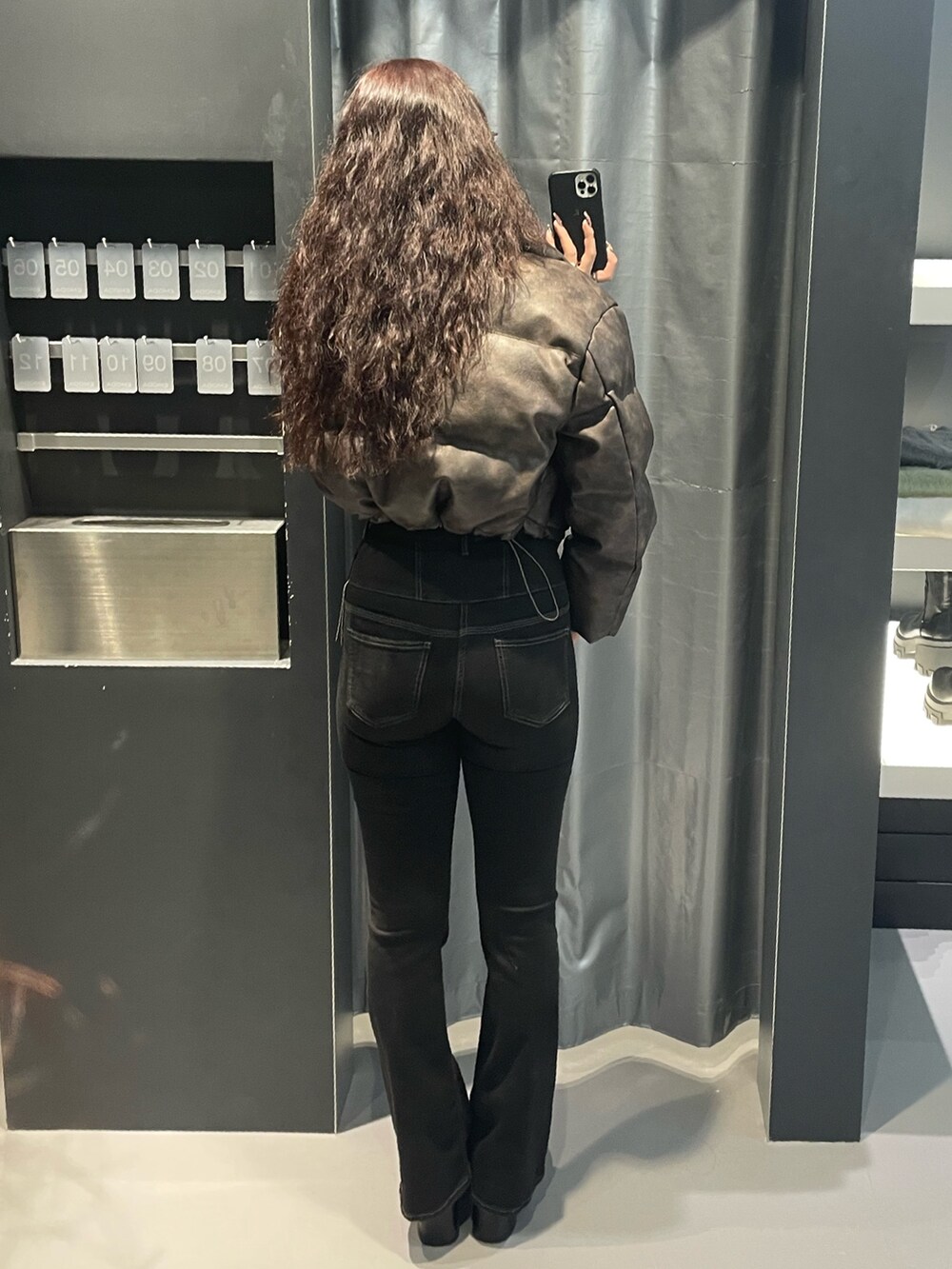 ホワイト系のニット/セーター、ブラウン系のダウンジャケット/コート、ブラック系のデニムパンツを着用したレディースの冬コーディネートの3枚目の写真