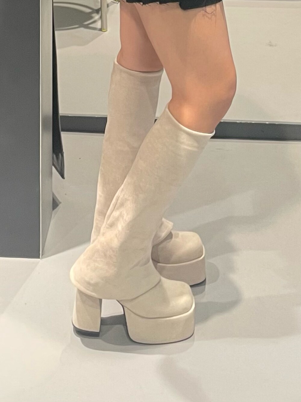 ブラック系のパーカー、ホワイト系のブルゾン、ブラック系のスカートを着用したレディースの秋コーディネートの6枚目の写真