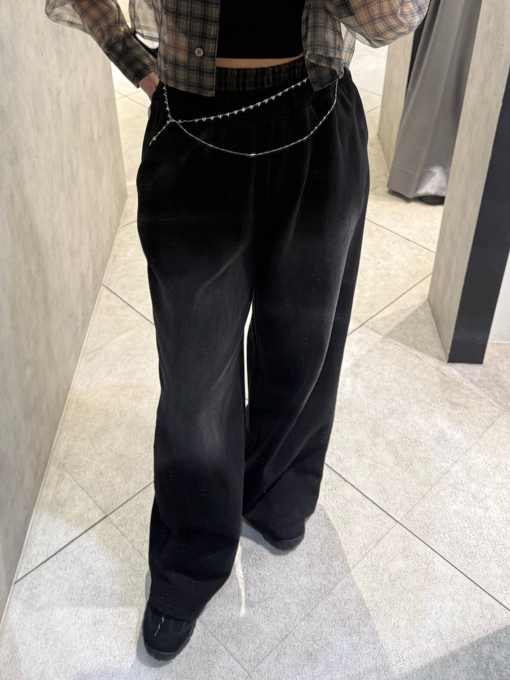 ベージュ系のシャツ/ブラウス、ブラック系のニット/セーター、ブラック系のスウェットパンツを着用したレディースの春コーディネートの5枚目の写真