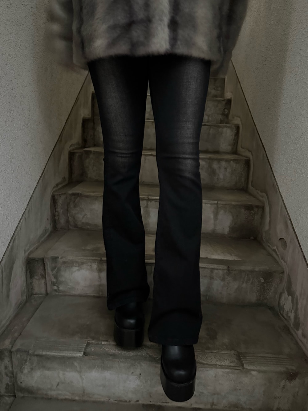 グレー系のその他アウター、ブラック系のデニムパンツ、ブラック系のブーツを着用したレディースの秋コーディネートの6枚目の写真