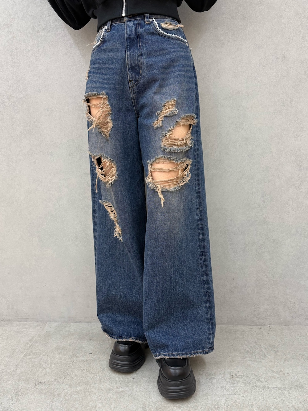 ブラック系のパーカー、ブルー系のデニムパンツ、ブラック系のローファーを着用したレディースの冬コーディネートの5枚目の写真