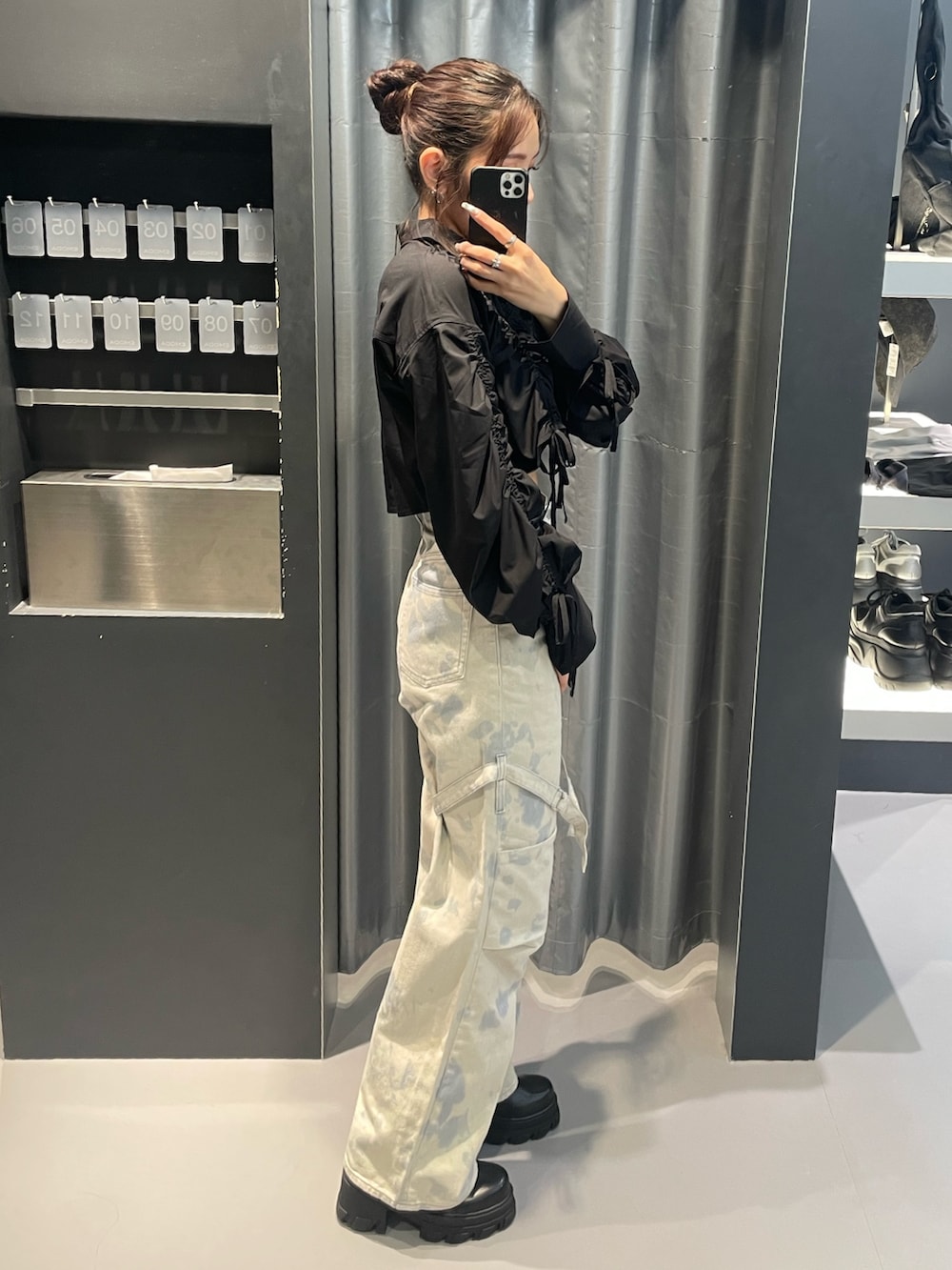 ブラック系のシャツ/ブラウス、ホワイト系のデニムパンツ、ブラック系のブーツを着用したレディースの春コーディネートの2枚目の写真