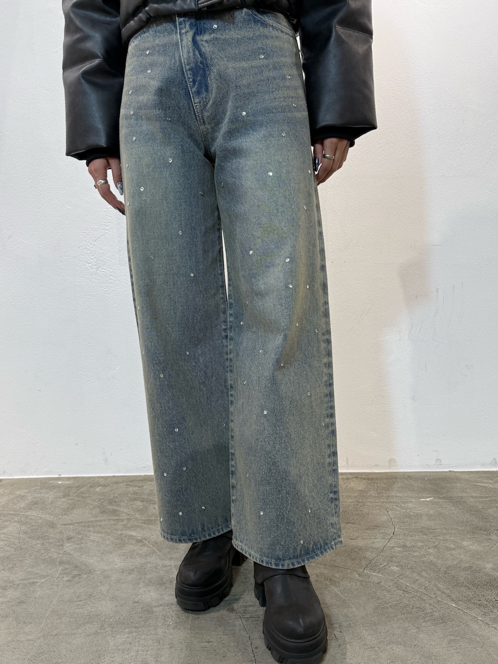 ブラック系のダウンジャケット/コート、ブルー系のデニムパンツ、ブラック系のブーツを着用したレディースの冬コーディネートの5枚目の写真