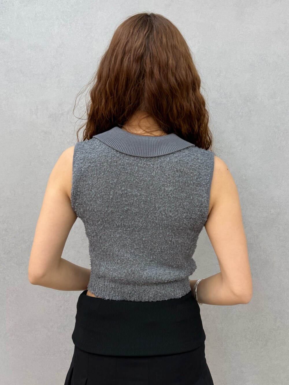 ブラック系のスカート、ブラック系のサンダル、グレー系のニット/セーターを着用したレディースの夏コーディネートの6枚目の写真