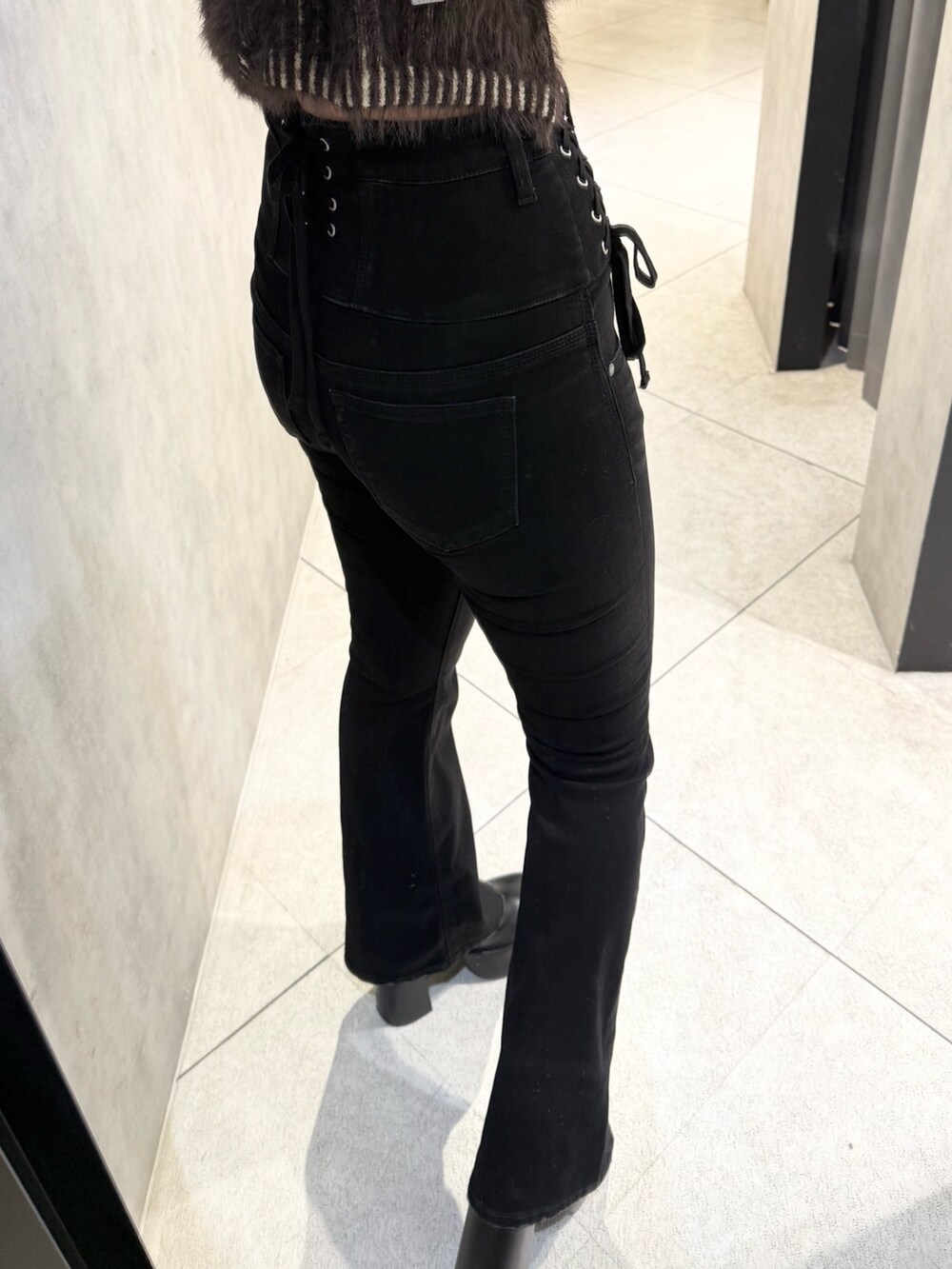 グレー系のニット/セーター、ブラック系のブーツ、ブラック系のデニムパンツを着用したレディースの秋コーディネートの7枚目の写真