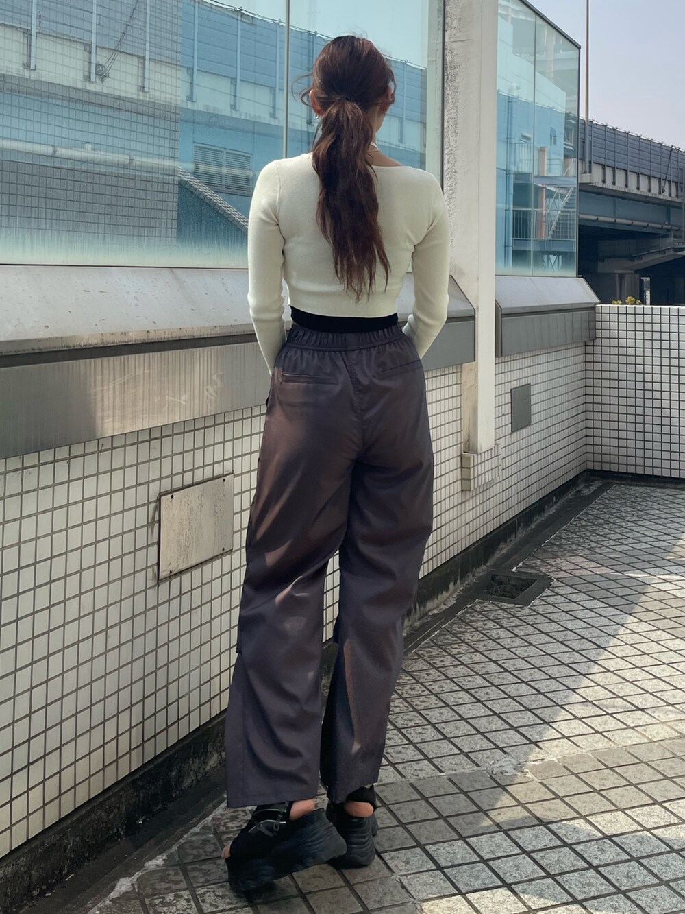 ホワイト系のニット/セーター、ブラック系のTシャツ/カットソー、ブラウン系のその他パンツを着用したレディースの春コーディネートの3枚目の写真