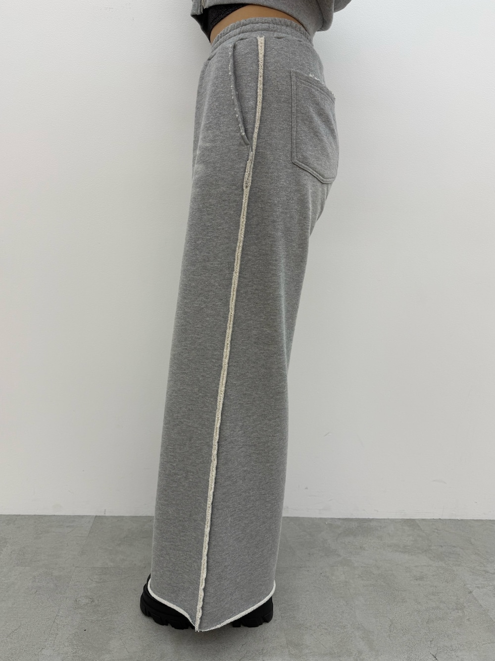 グレー系のパーカー、ブラック系のキャミソール、グレー系のスウェットパンツを着用したレディースの夏コーディネートの6枚目の写真