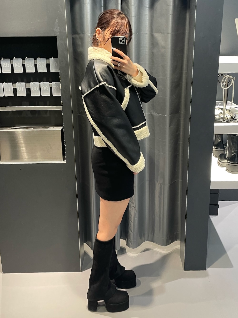 ホワイト系のニット/セーター、ブラック系のスカート、ブラック系のブルゾンを着用したレディースの冬コーディネートの2枚目の写真